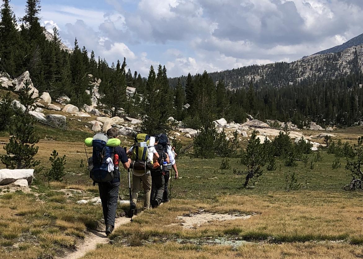 Teen participants hiking in mountainous scenery