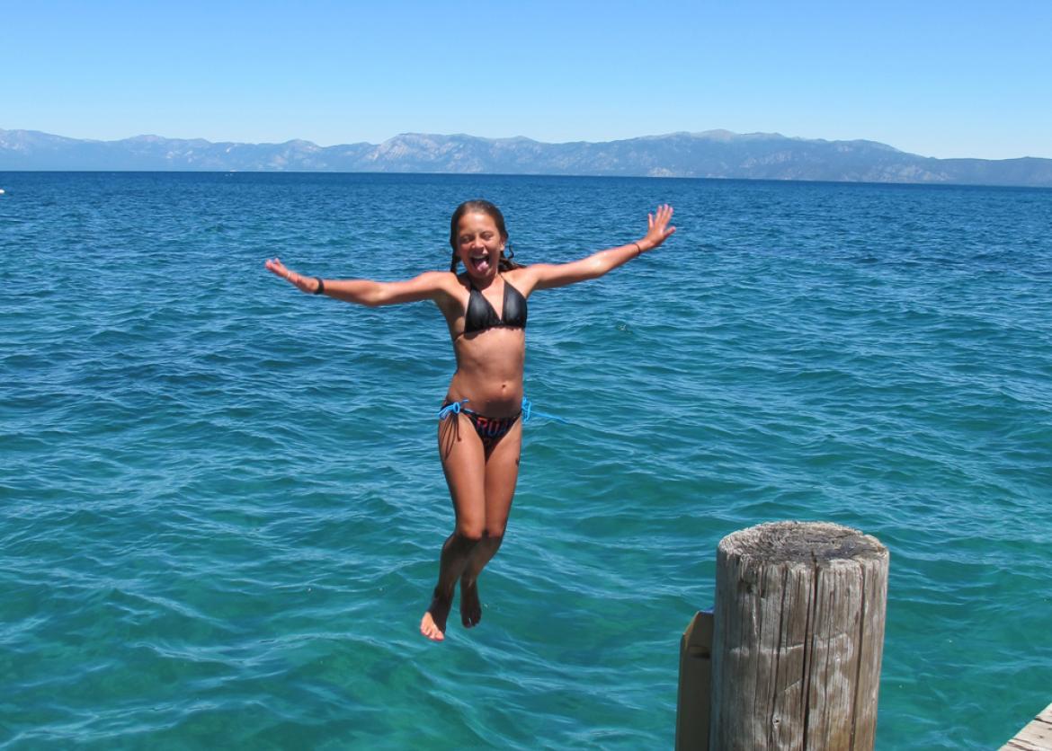 A girl jumping down to the water.