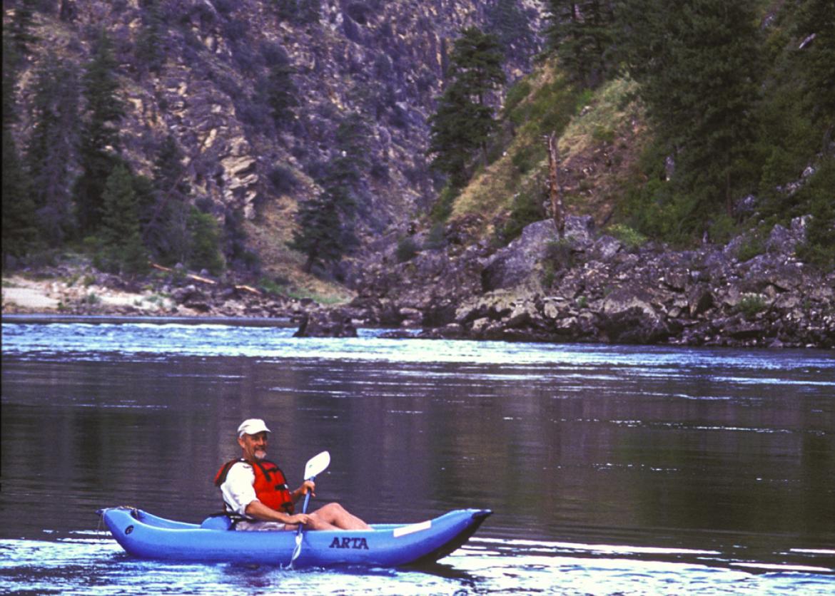 A man floats in a kayak on the water.