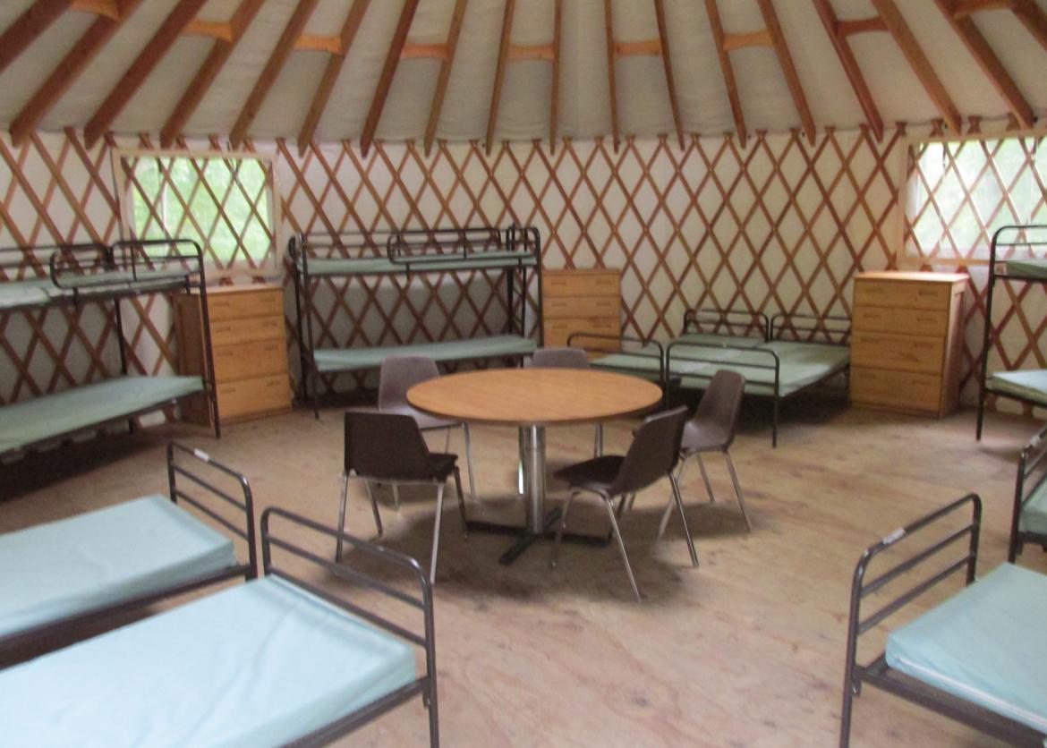 Bunk beds, a table, and chairs inside of the teepee.