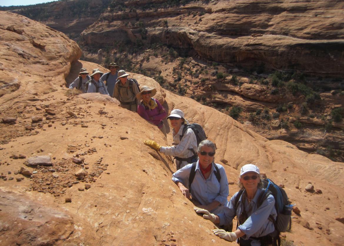 A group of hikers standing in a single line in an underground trail