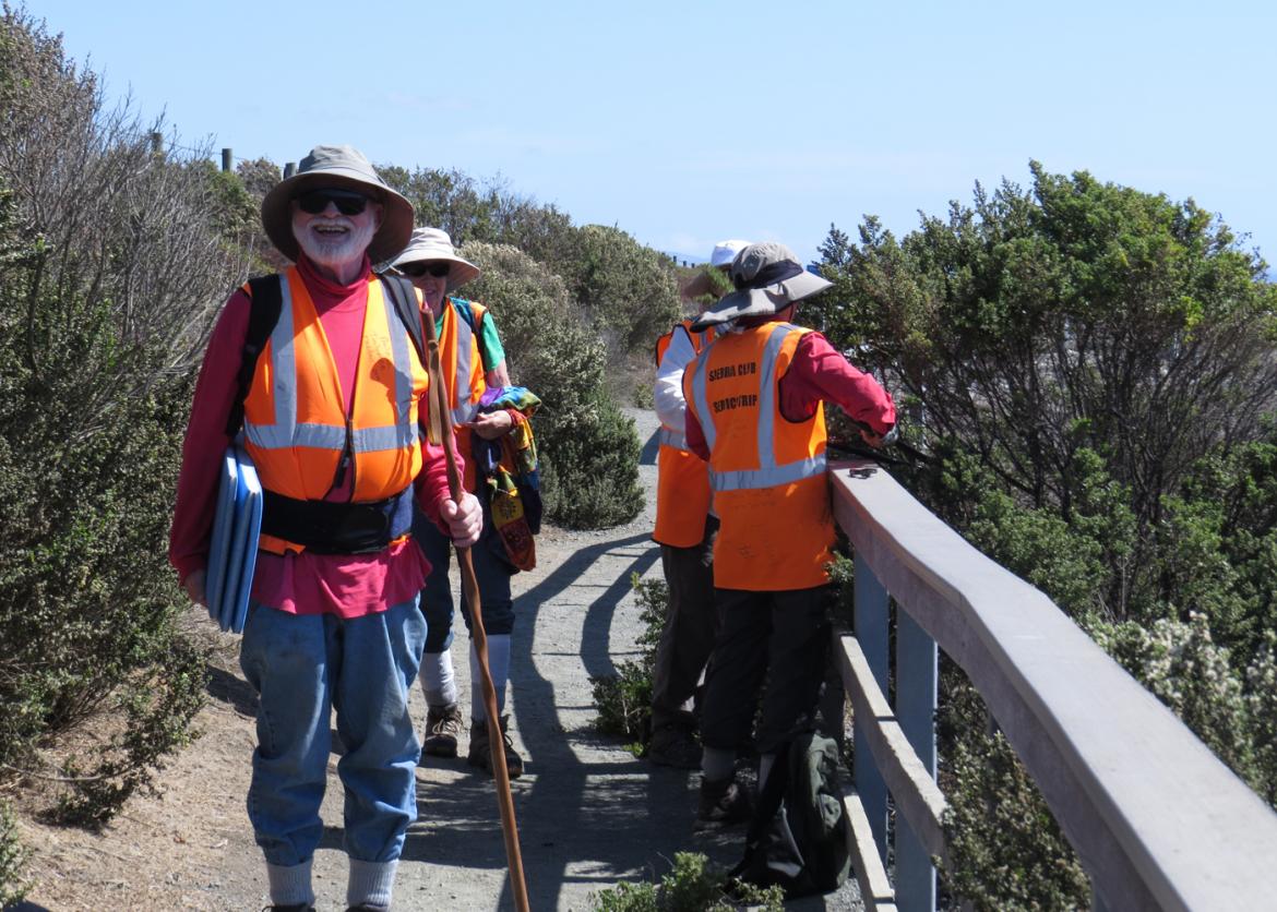 People in orange safety vests walking on the trail