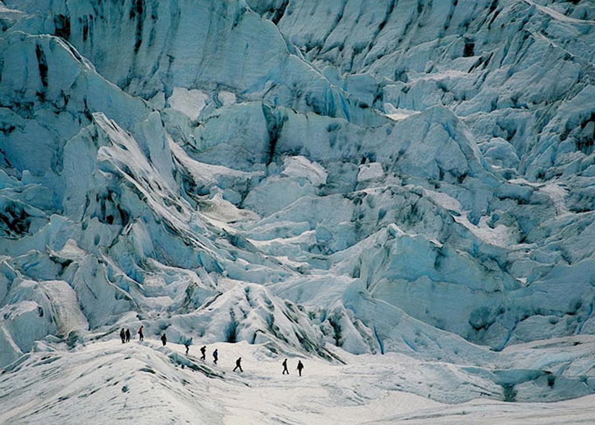 People hiking through the ice mountains.