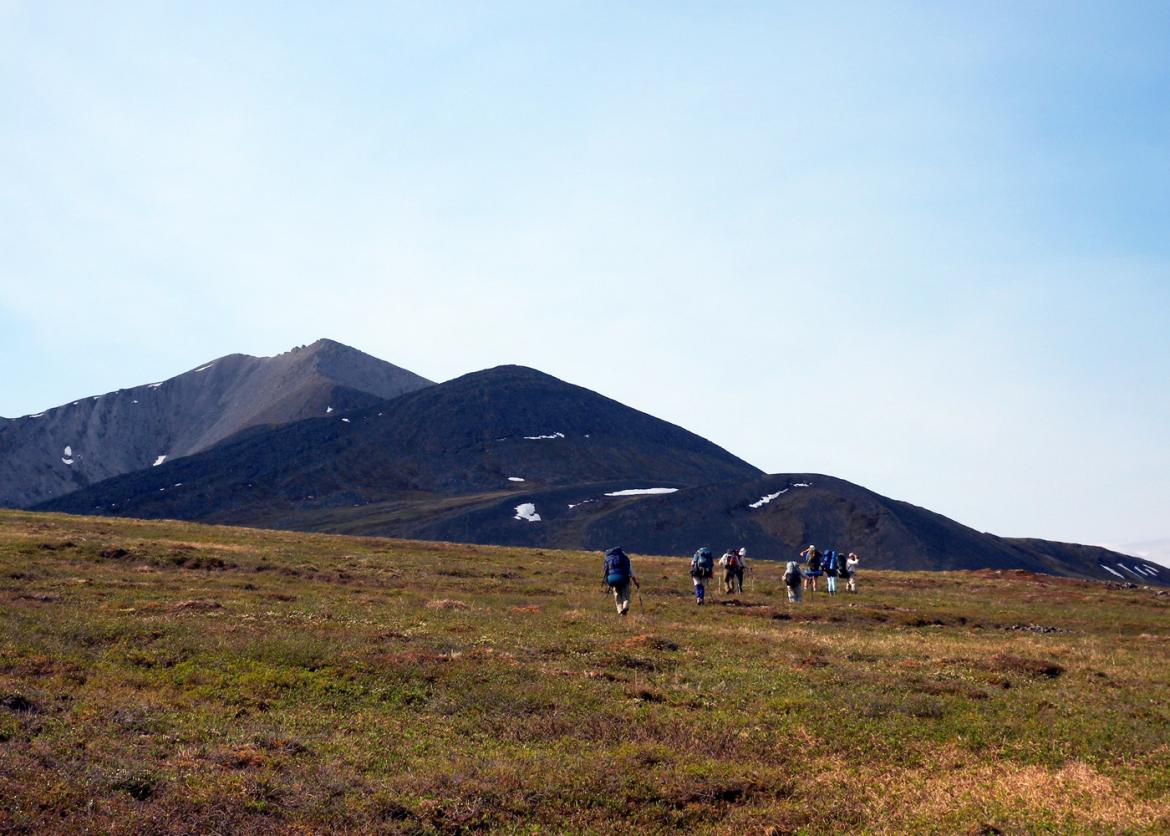 Participants hike together toward a mountain over open terrain.