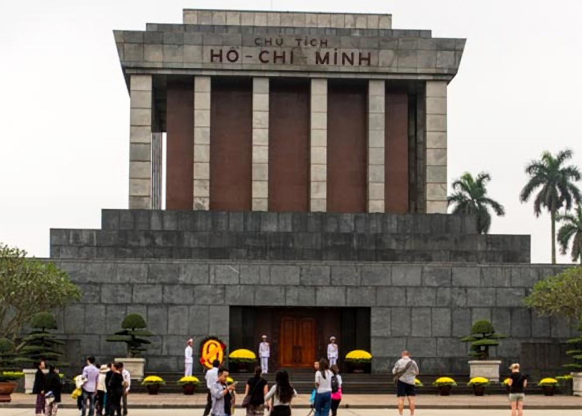 A stone building with pillars and engraved text which reads "Chu Tich Ho Chi Minh."