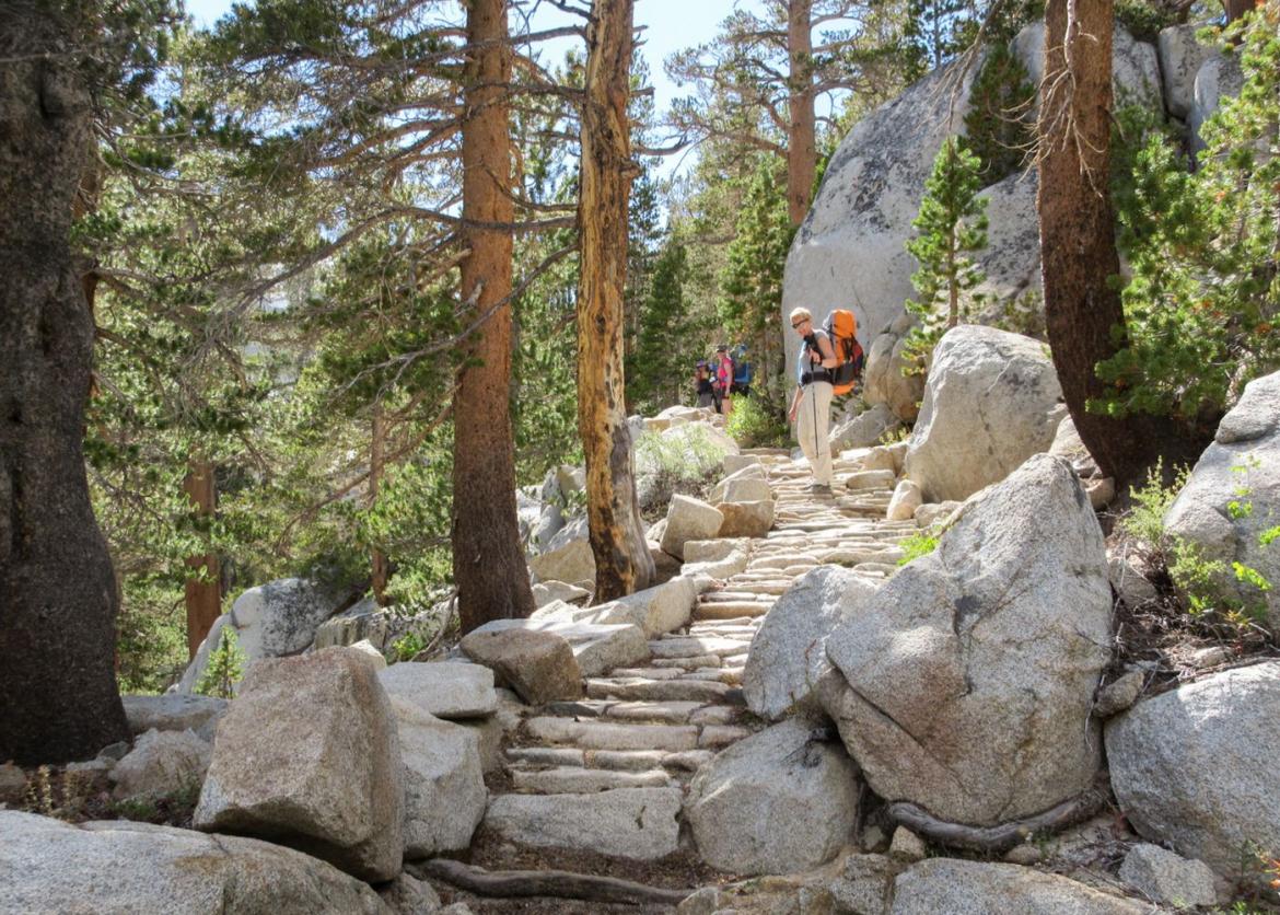 Hikers climbing up rocky stairs.