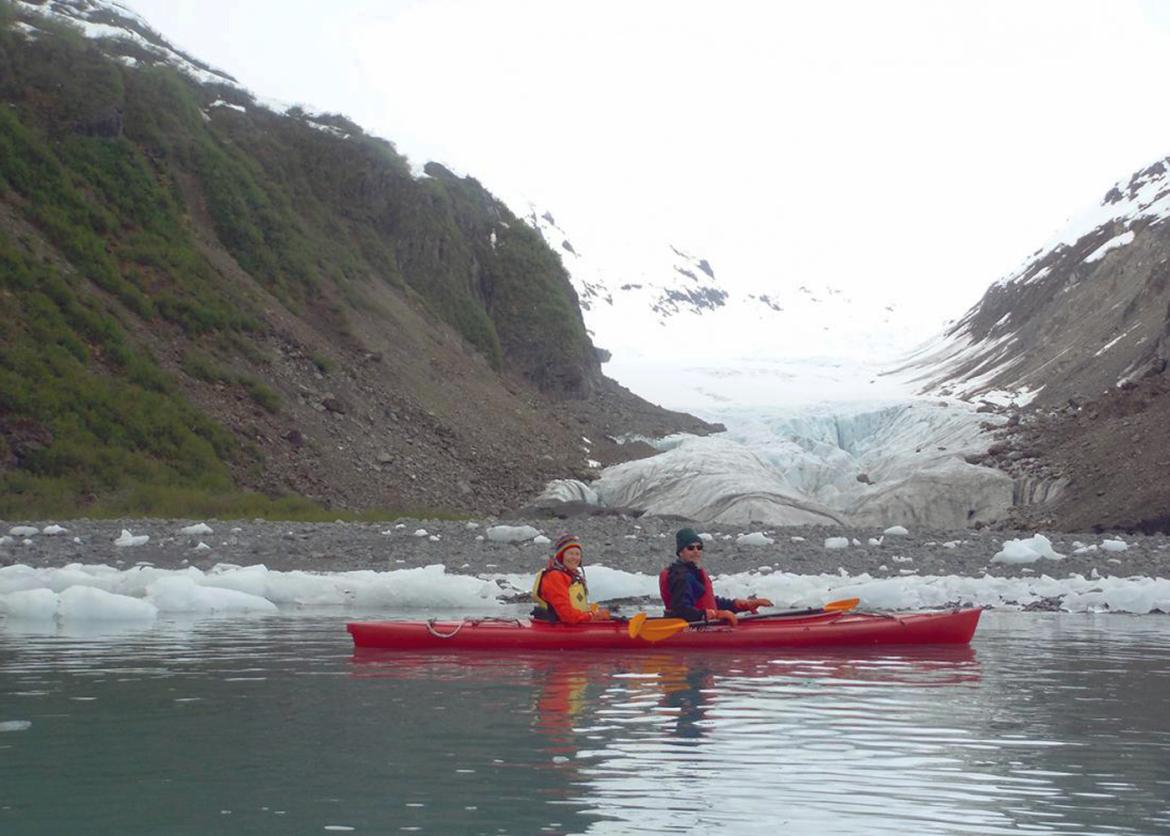 Two kayakers smiling in front of glacier in Prince William Sound, Alaska