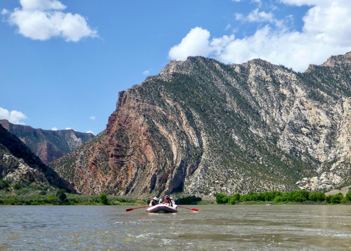 A group rafting in the middle of the lake with the mountains in the background