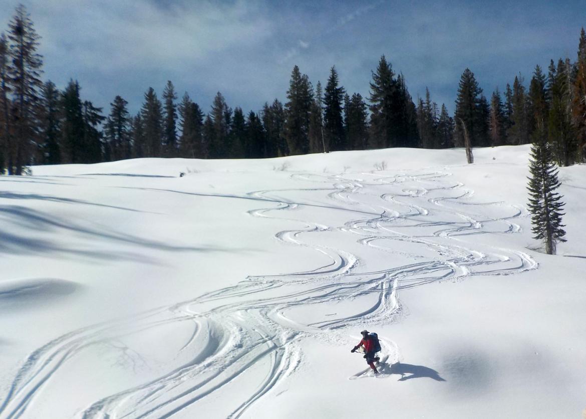 Person backcountry skiing down the snow-covered slopes at Lassen Volcanic National Park, California