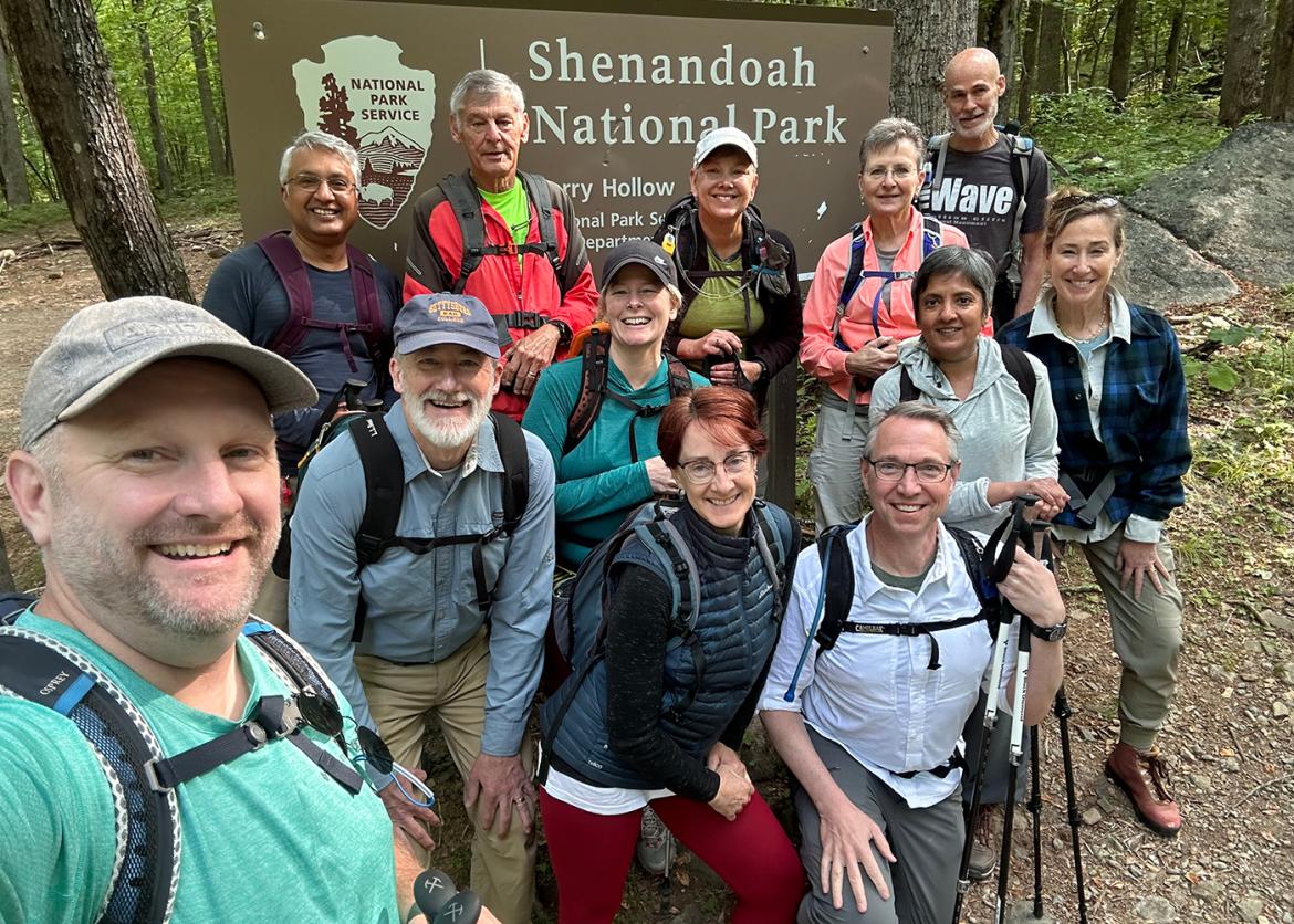 Twelve smiling participants pose in front of a sign reading Shenandoah National Park.