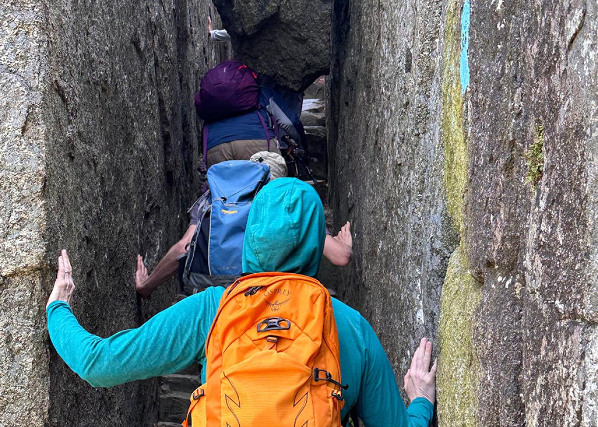 Participants between a narrow natural formed alleyway of rock.