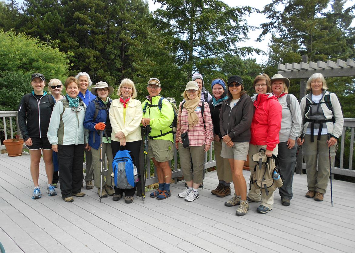 A group smiling and posing in front of the lodging area.
