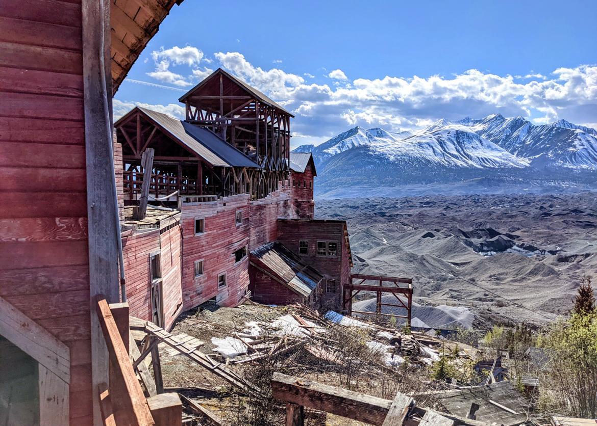Abandoned Kennecott mine in Alaska, with snow-capped mountains in the background