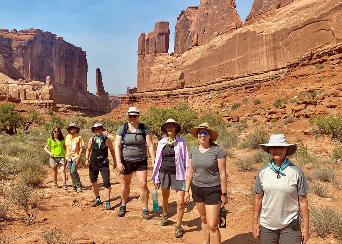 Trip participants hiking through red rock formations