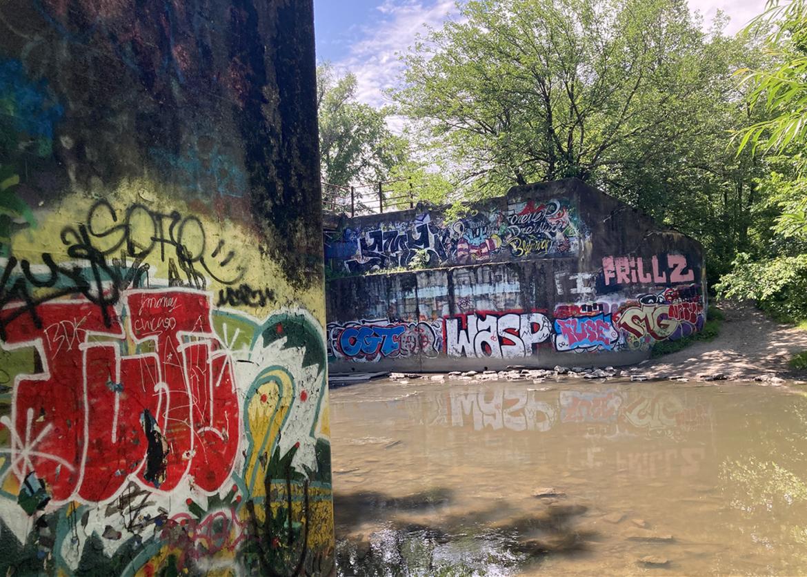 Graffiti-covered walls on either side of river