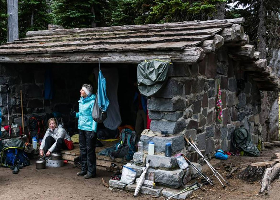 Women resting at a rustic hut along the hiking trail