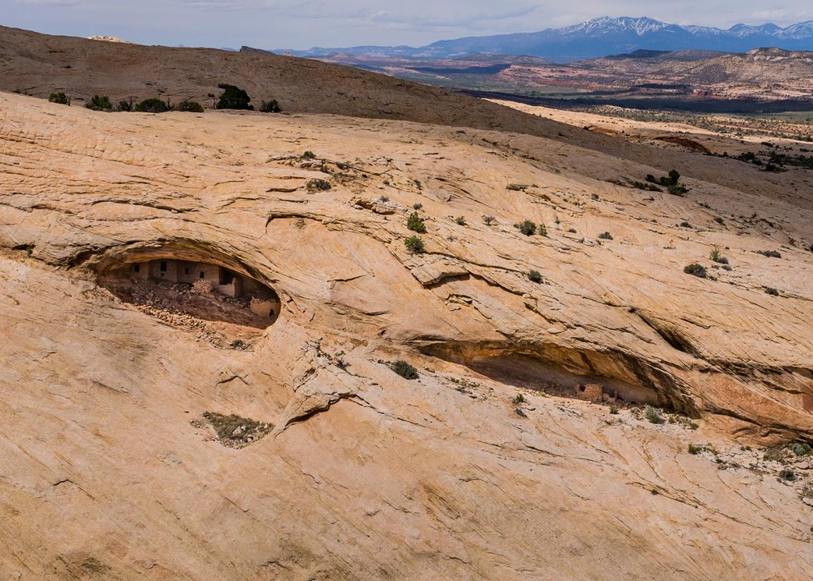 Indigenous structures built into holes in a rock face.