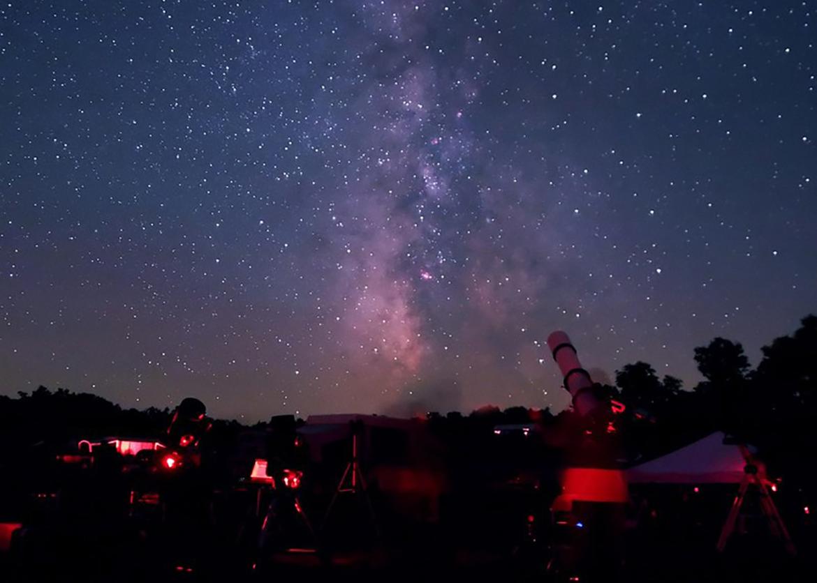 Telescope and other equipment in the foreground against a starry sky featuring the Milky Way in Cherry Springs State Park, Pennsylvania
