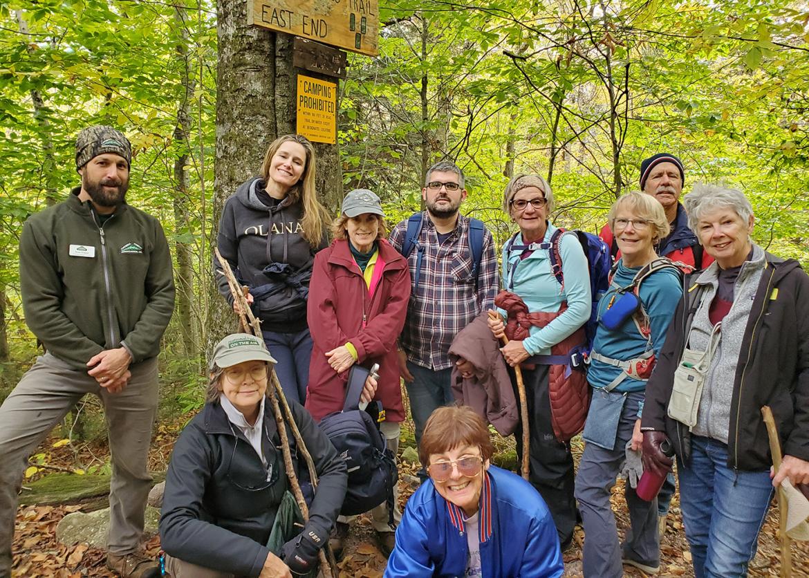 Trip participants pose on a hike in the forest