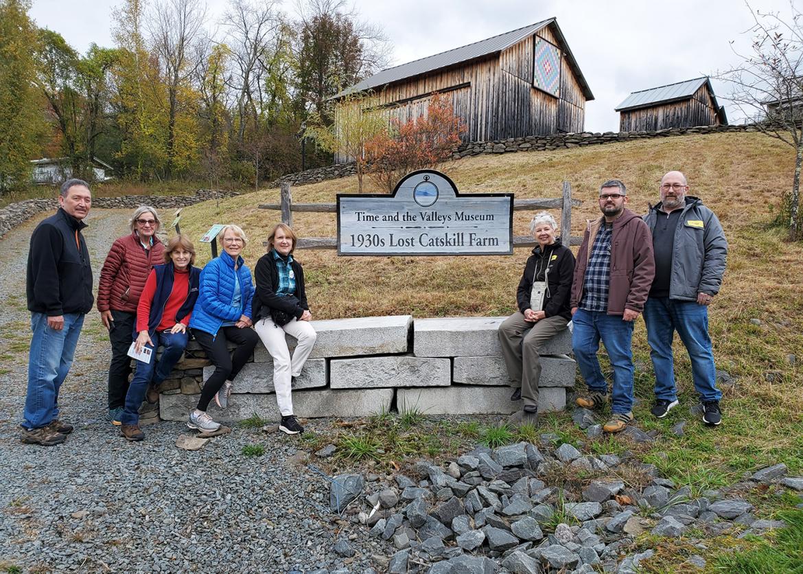 Trip participants pose with Time and the Valleys Museum sign