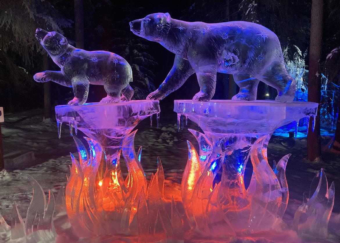 Sculpture of two bears standing on decorated plinths, the entire thing made out of ice.