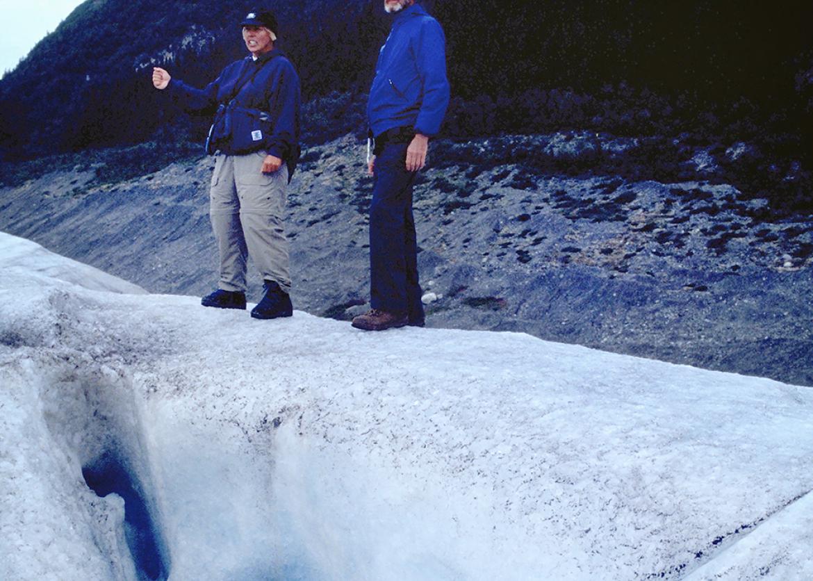 Two people in front of icy crevasse in Alaska