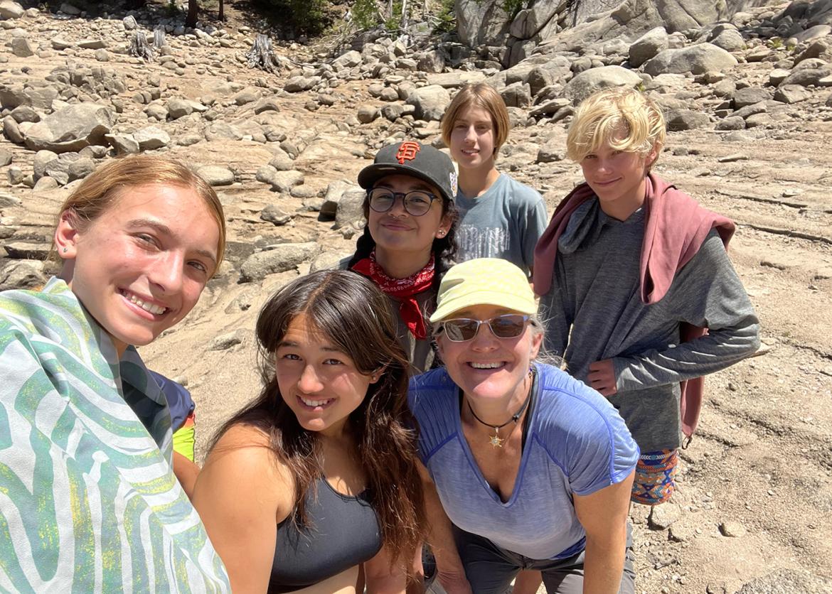 Group of teen trip participants pose for a selfie along the hiking trail.