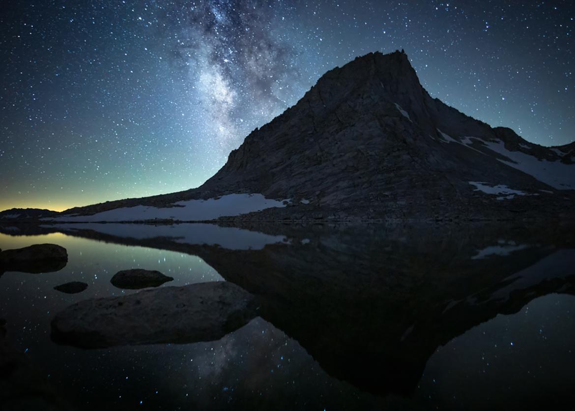 Photo of milky way and starry sky over mountain and lake