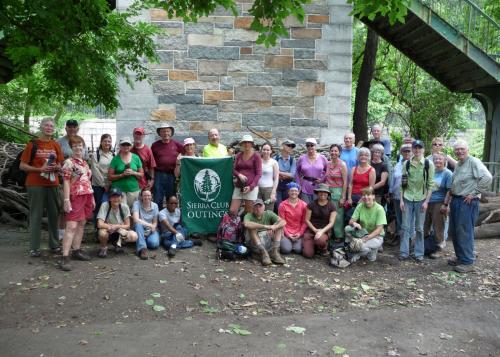 A group photo of thirty-two participants posing with a Sierra Club flag.