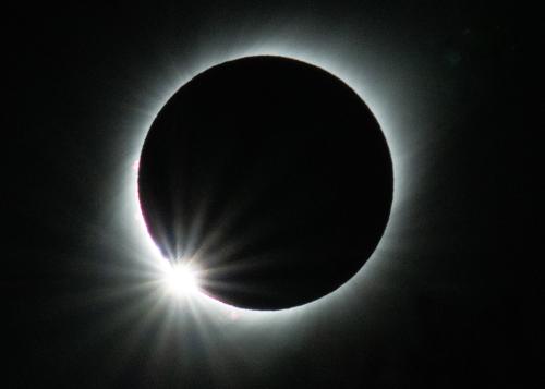 A total solar eclipse.  A dark circle rimmed with light in a black sky.