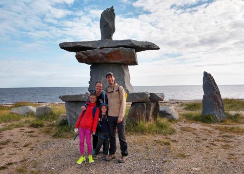 Family of four in front of an Inuksuk in Churchill, Manitoba, Canada